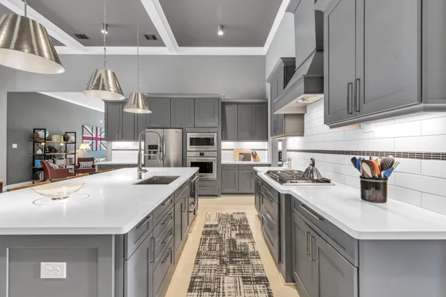 Grey kitchen cabinetry with large island and adjoining living area