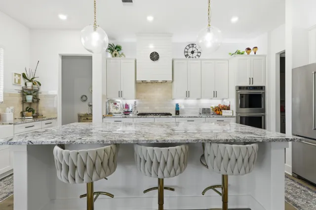 White kitchen with marble-pattern island and pendant lights