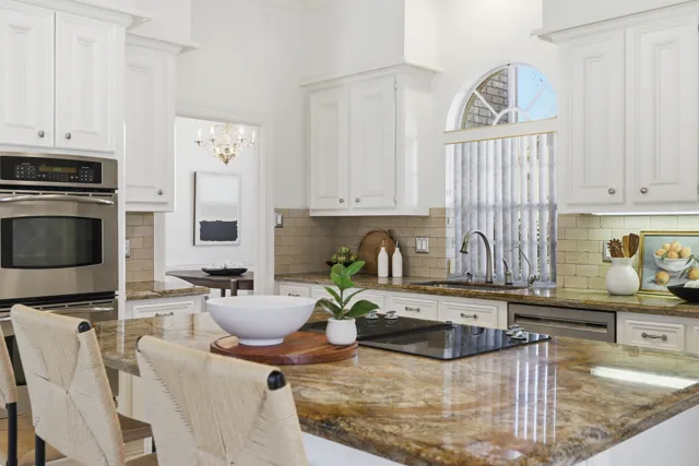 Bright kitchen with decorative cabinetry and arched window