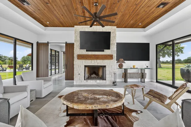 Living room with wood ceiling, fireplace and expansive windows