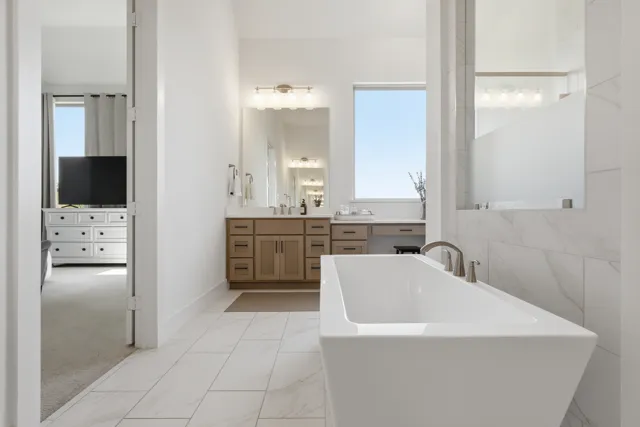 Light-filled bathroom with freestanding tub and tiled shower