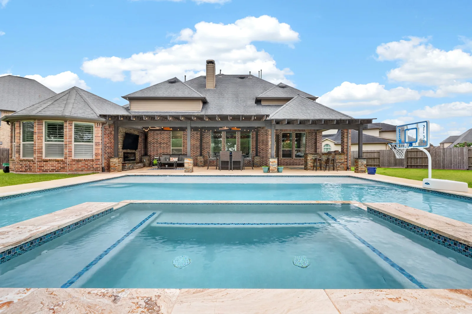 Rear elevation, covered patio and swimming pool photographed together