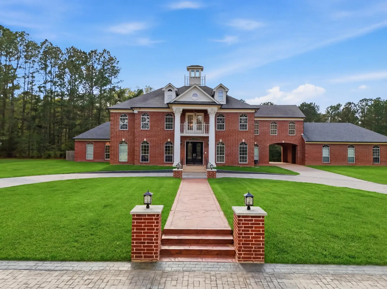 Brick home with columned entrance, daytime