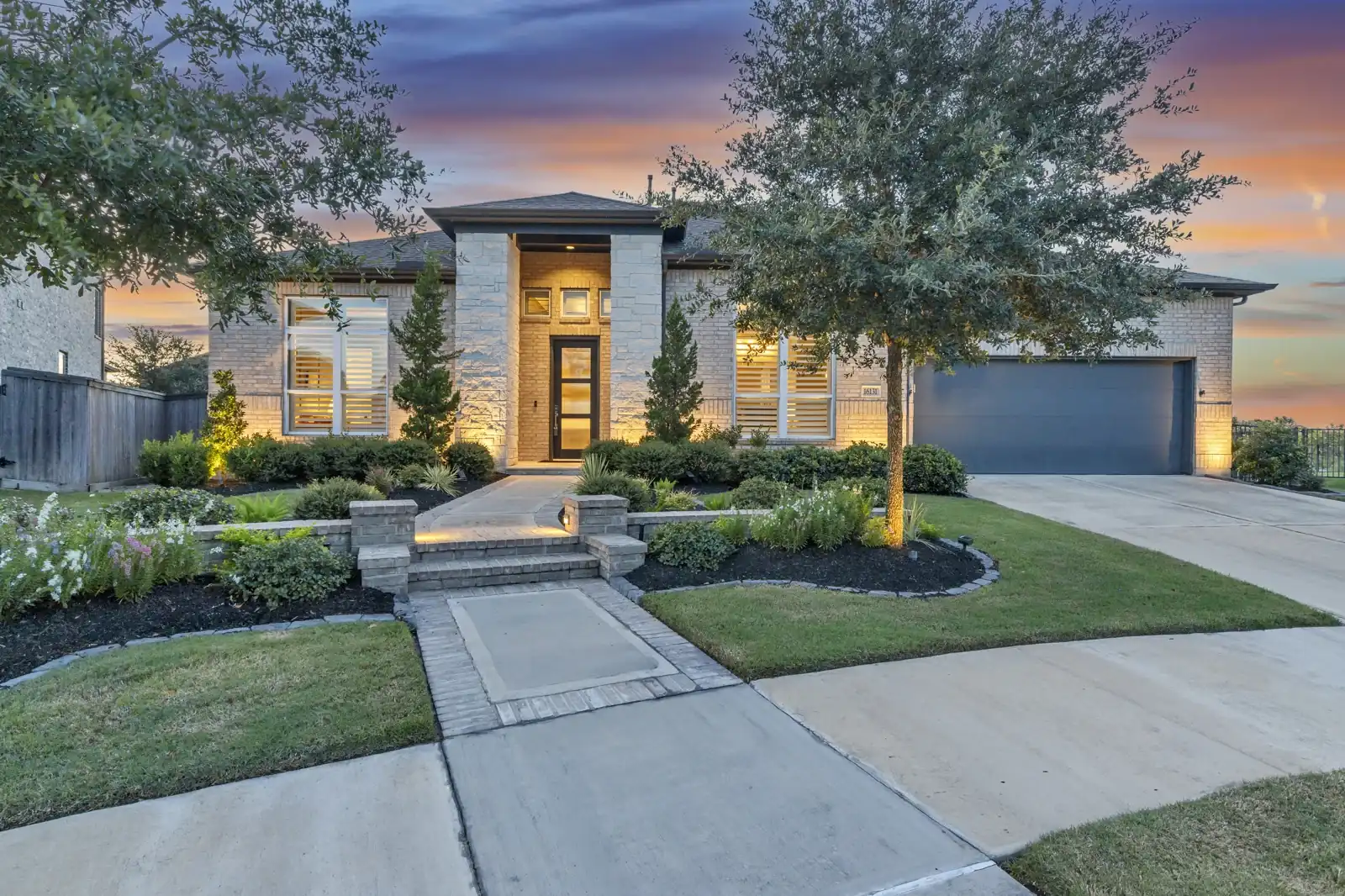 Contemporary front elevation with warm entry lighting at dusk