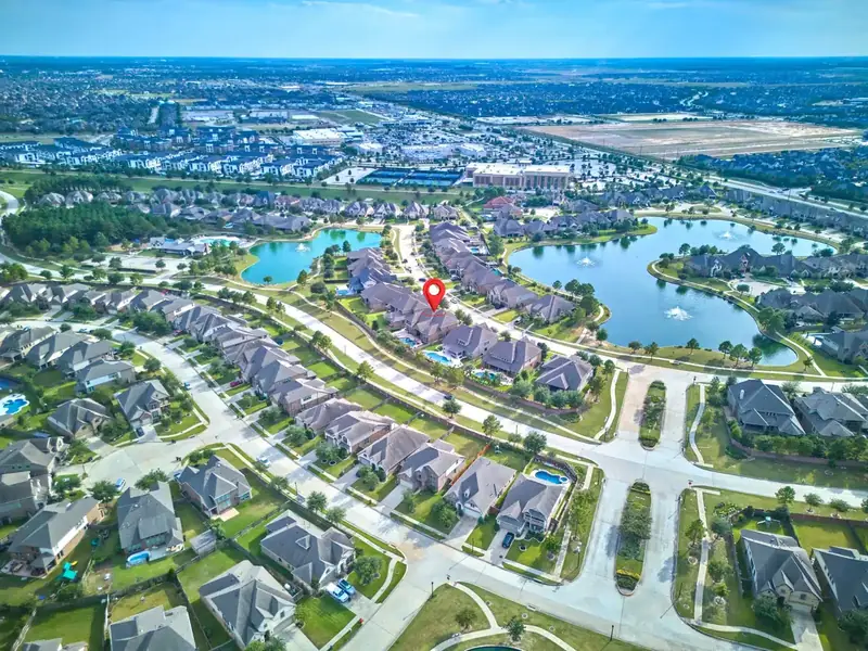Aerial view of a residential neighborhood with lakes and a marked property